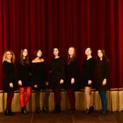 Le sette ragazze dell'ensemble Silence Please davanti al sipario del Teatro Ciro Pinsuti